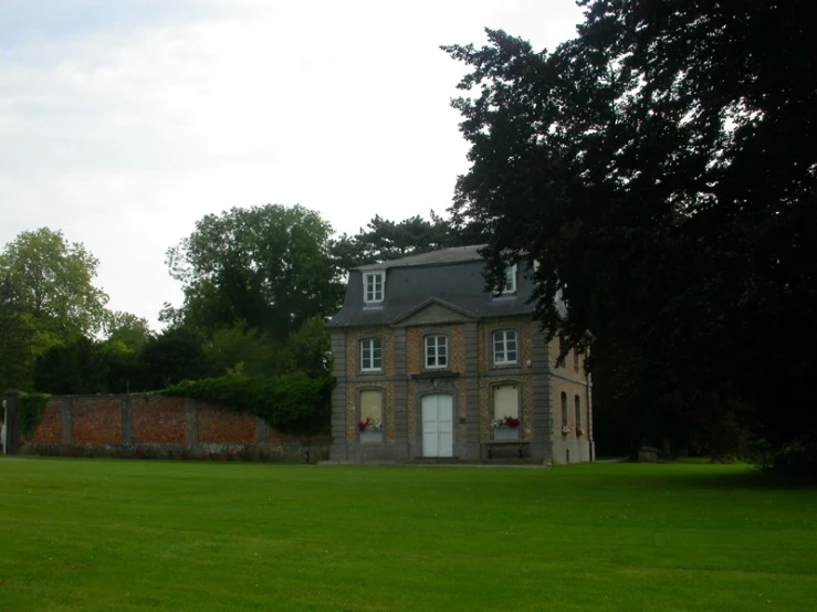 a house is shown in a yard with a fence around it