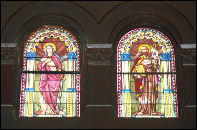 two stained glass windows in the side of a building