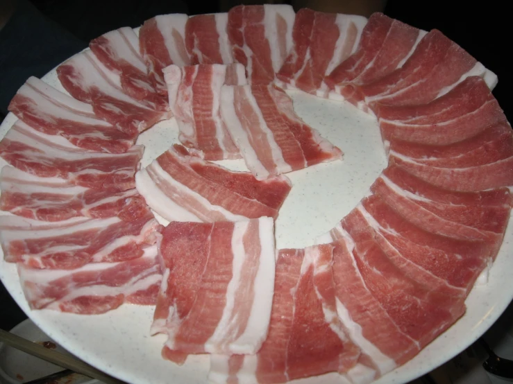 meat is arranged in layers on a plate