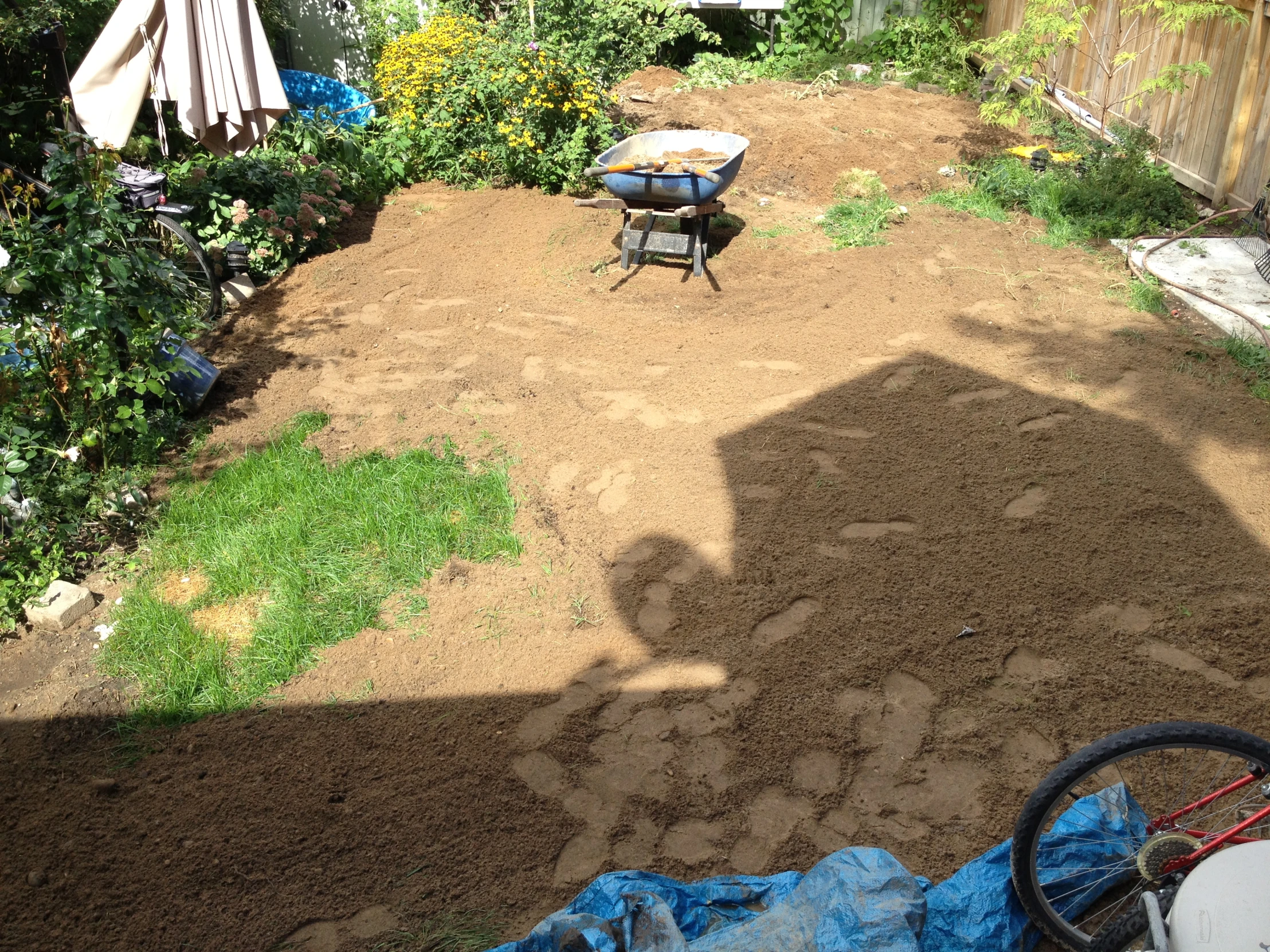 a view of a backyard with a table, umbrella and a bicycle