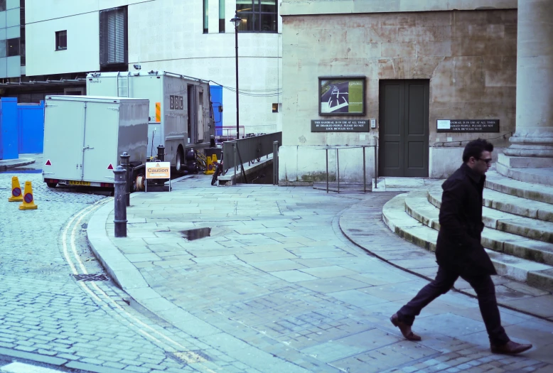 the man is walking through town with many garbage cans