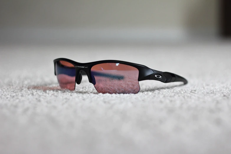 an image of a pair of sunglasses laying on a white surface