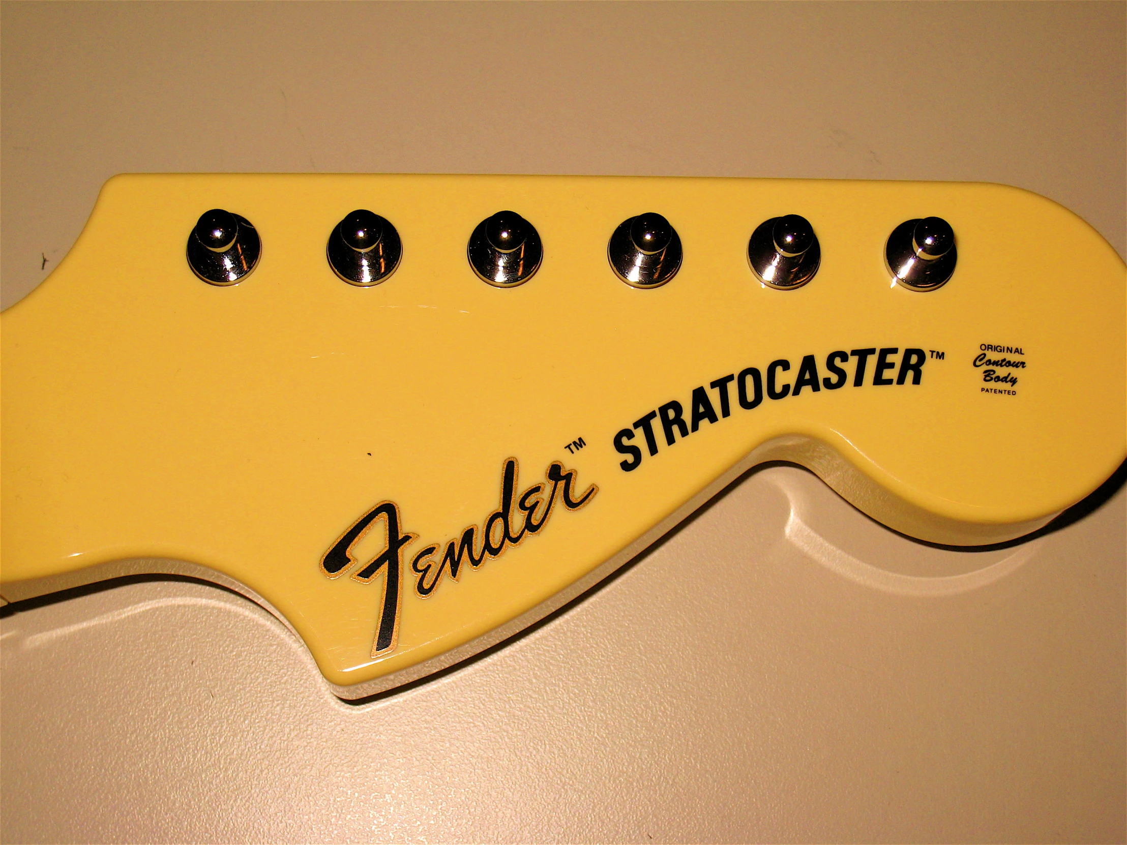 a yellow guitar neck with the words fender stratologist on it