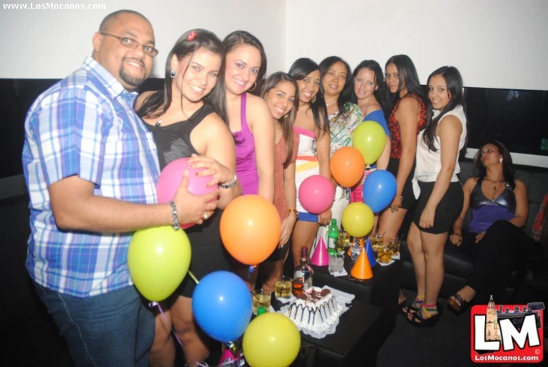 the girl group is posing with colorful balloons