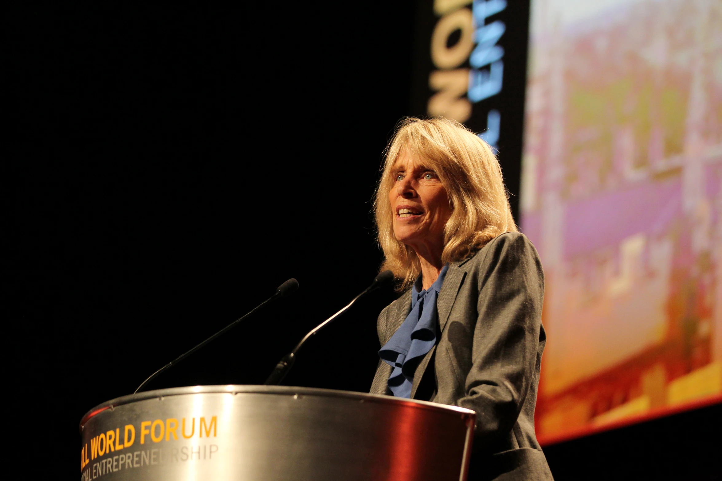 a woman stands at a podium at a convention