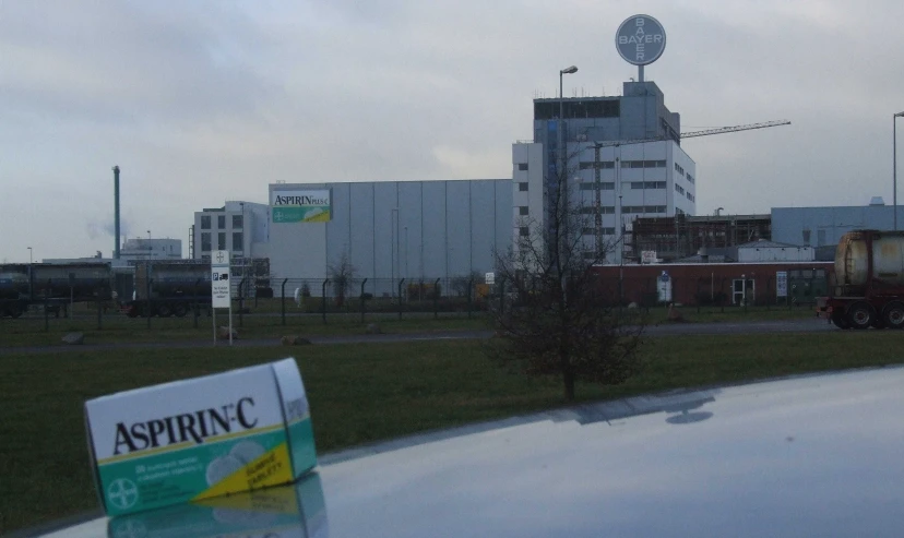 a parking lot with an aspignic sign in front of a factory