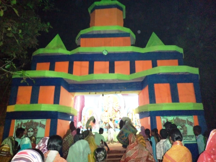 people gather outside a colorful shrine during the festival