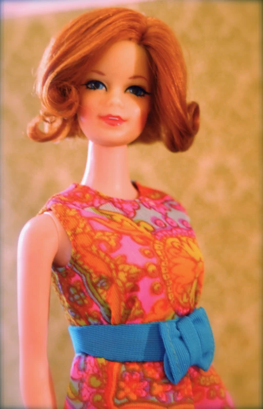 a barbie doll dressed in a dress with a blue bow on it's neck