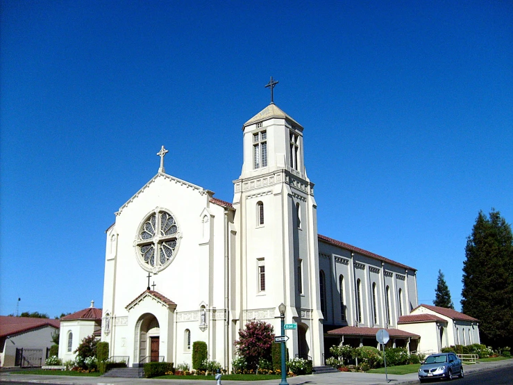 an old, white building is shown with its bell on the corner