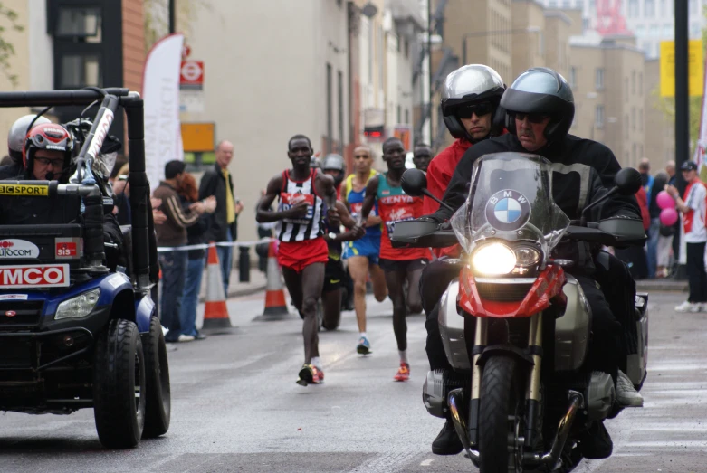 a group of men riding motorcycles down a street