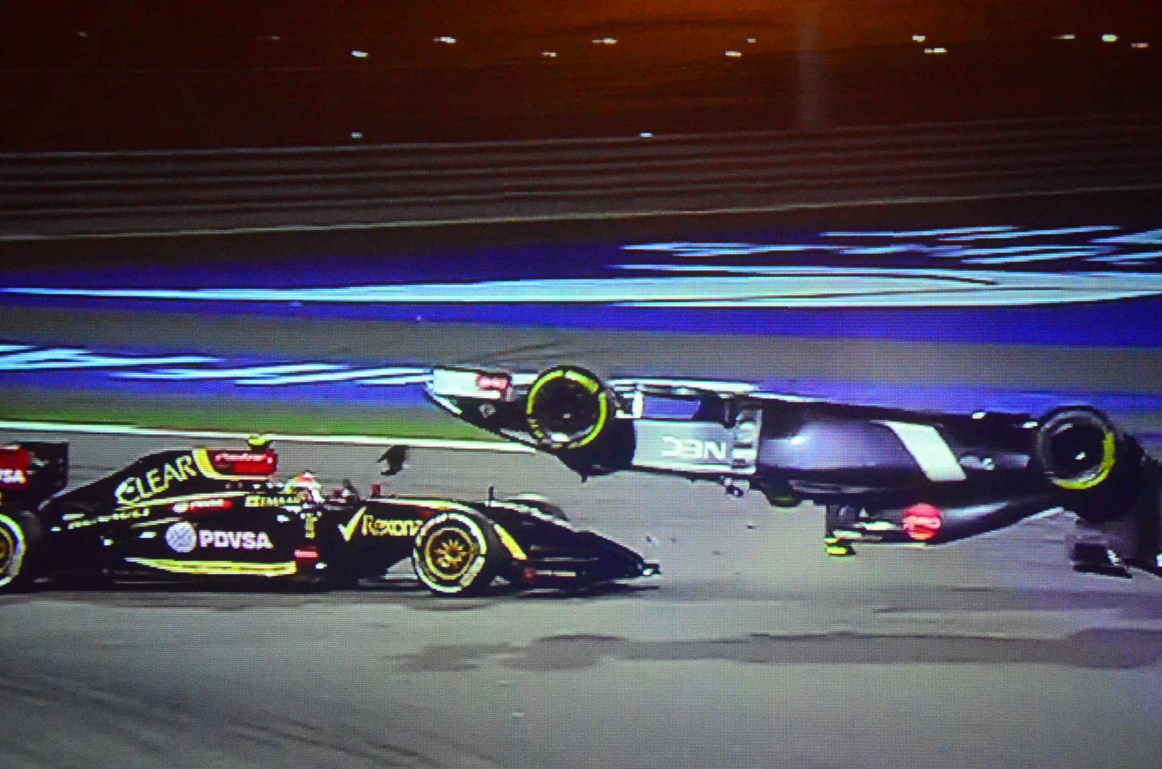 a race car being serviced and a man is hing his car away from the track