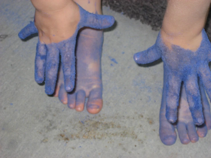 two hands that have blue paint on them