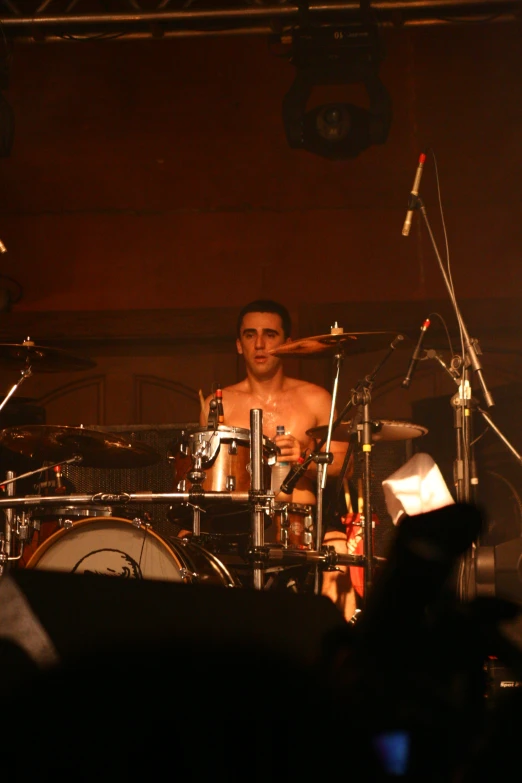 a person standing by a drum kit in a dark room