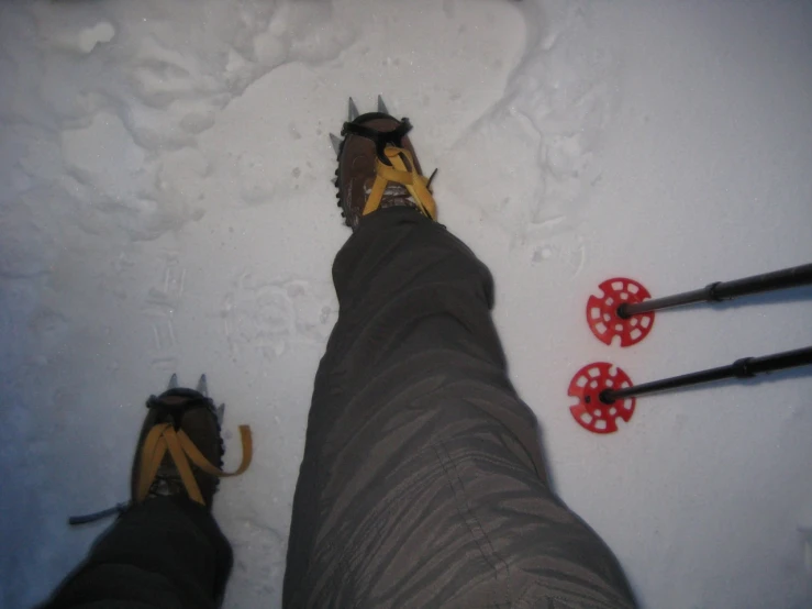 a skier's feet in the snow with red ski poles
