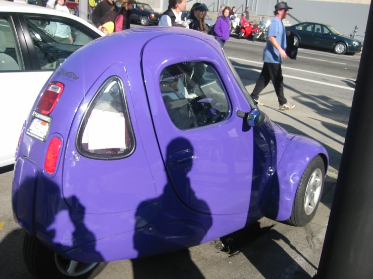 a purple car parked next to a white car on a road
