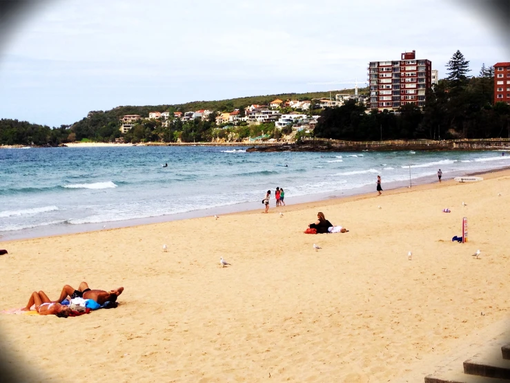 several people are laying down on the beach