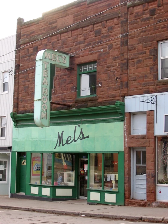 a building that is written mel's with a green sign