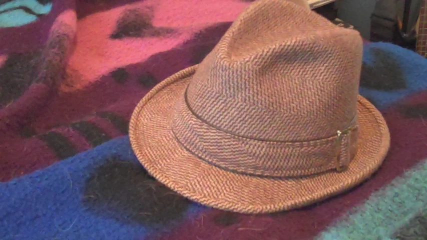 a small brown hat is lying on a blanket