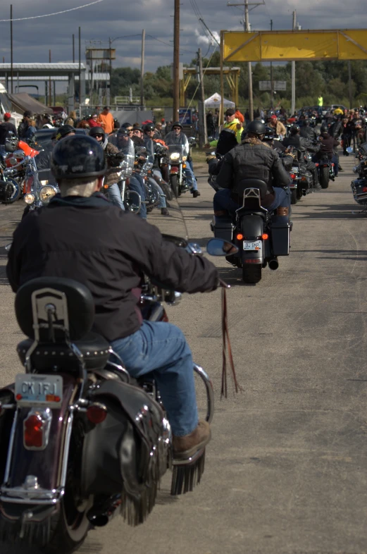 a large group of people riding motorcycles down a street