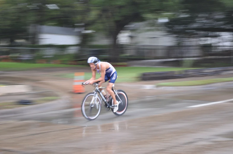 a man riding a bike on top of a wet road