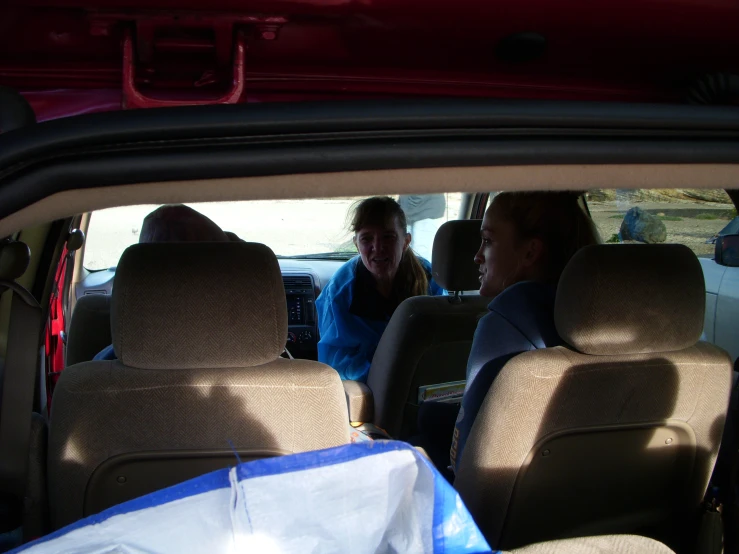 people are sitting in the back seat of a car