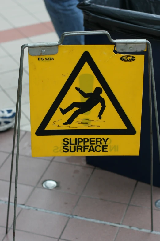 there is a sign warning people about slippery surfaces