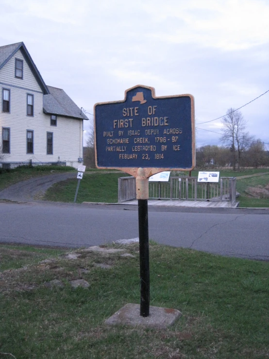 a sign in the middle of a grass yard