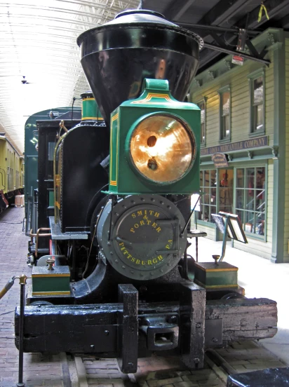 an old fashioned steam locomotive sits on some wood