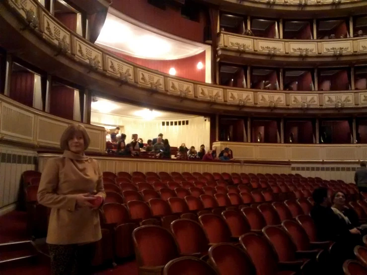 a woman standing next to some red chairs