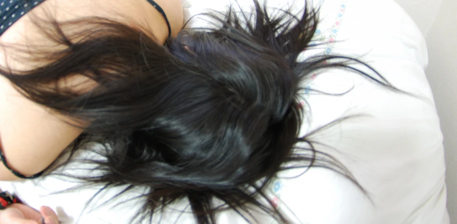 a girl laying in bed with her hair flowing