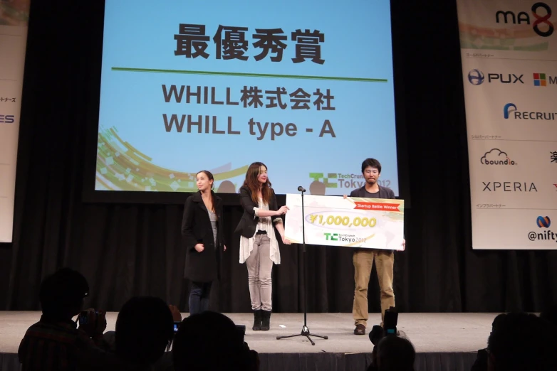 people giving a presentation in front of a large screen