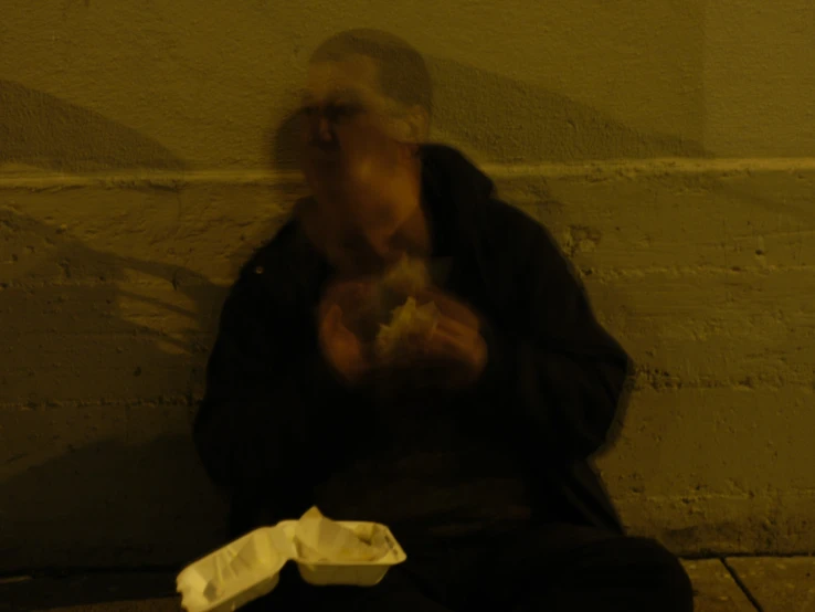 a man sitting on a bench eating food