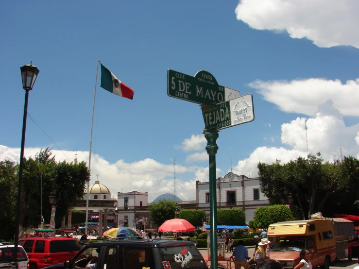 a large street sign near some parked cars and buildings