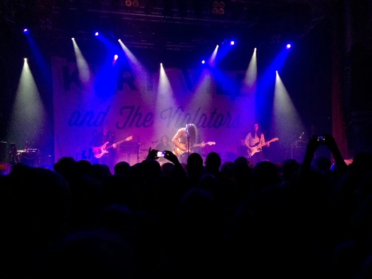 the audience at a concert is in front of purple lights