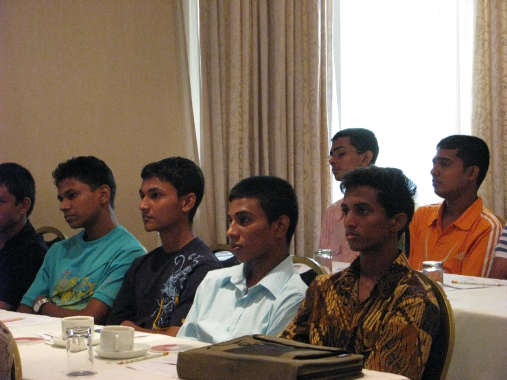 seven people in a meeting looking at one another