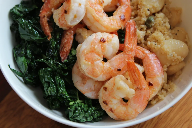 shrimp and kale with quishe rice on a table