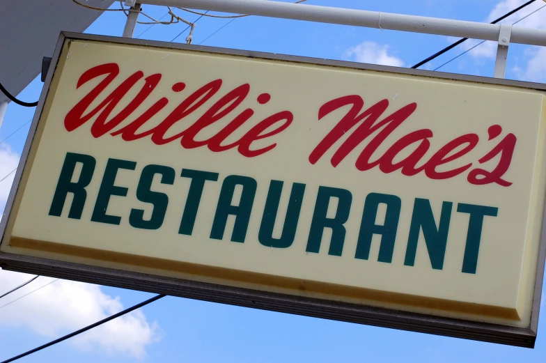 the restaurant sign for willie made's restaurant hanging from a pole