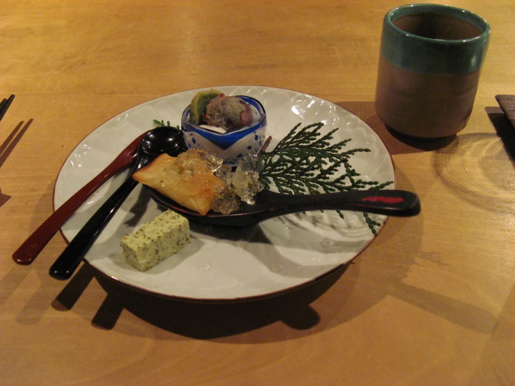 a plate filled with food and chopsticks next to a cup