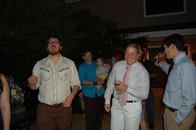 a man with a beard wearing a tie and a pink tie stands in front of a crowd