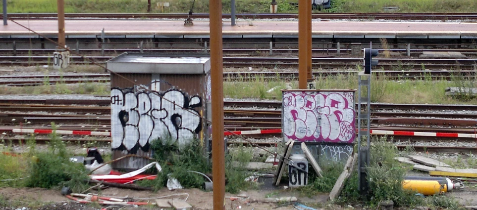 a train track with graffiti and an old sign