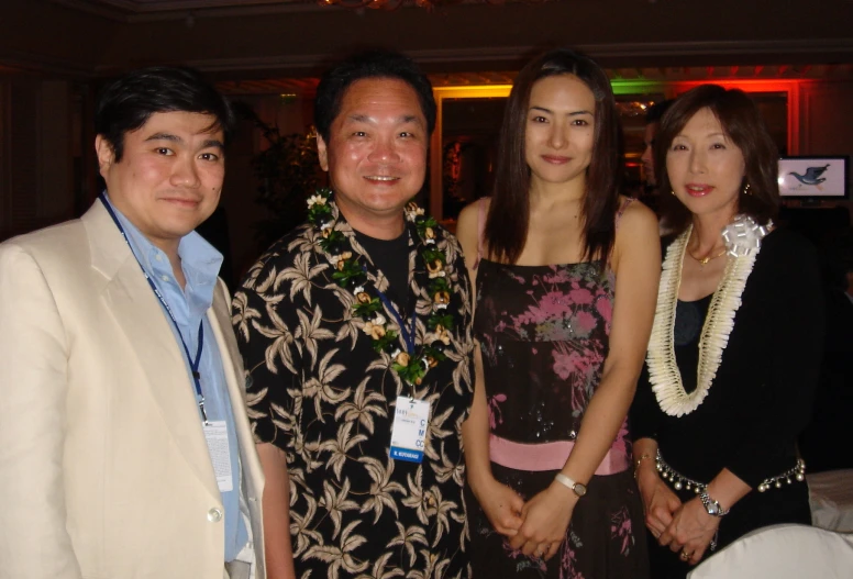 a woman in a flowery dress standing between two men and woman