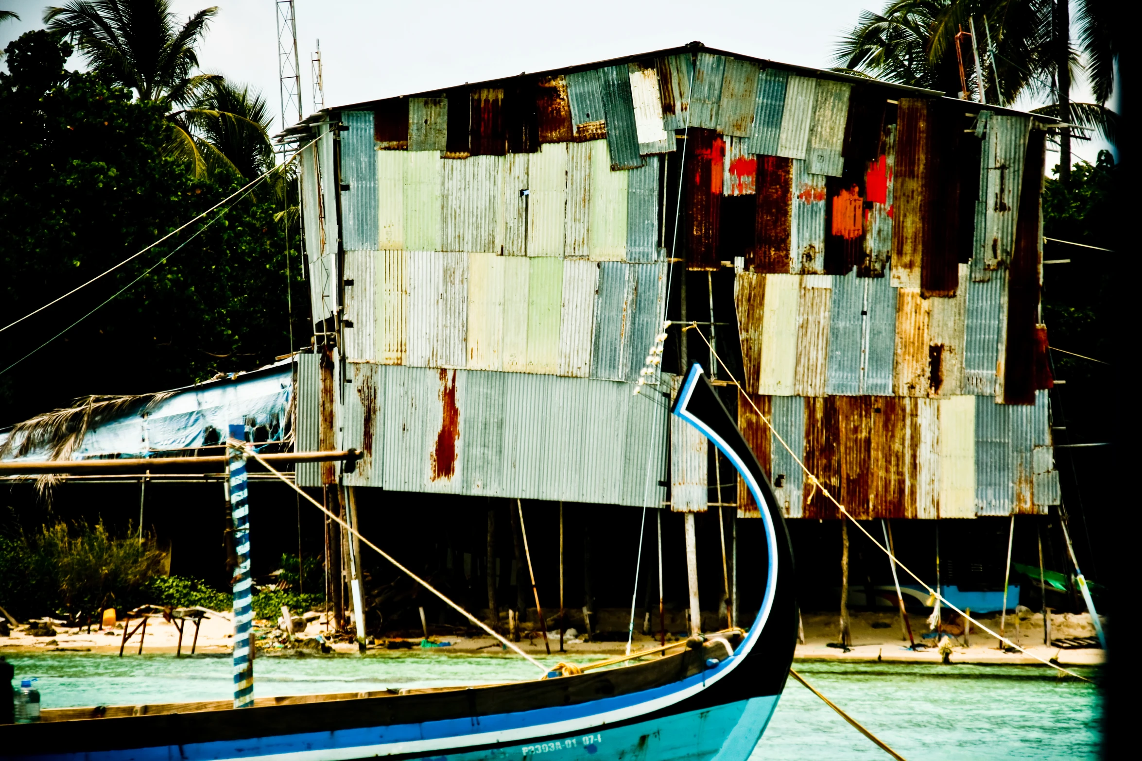 a blue and white boat docked next to a shack