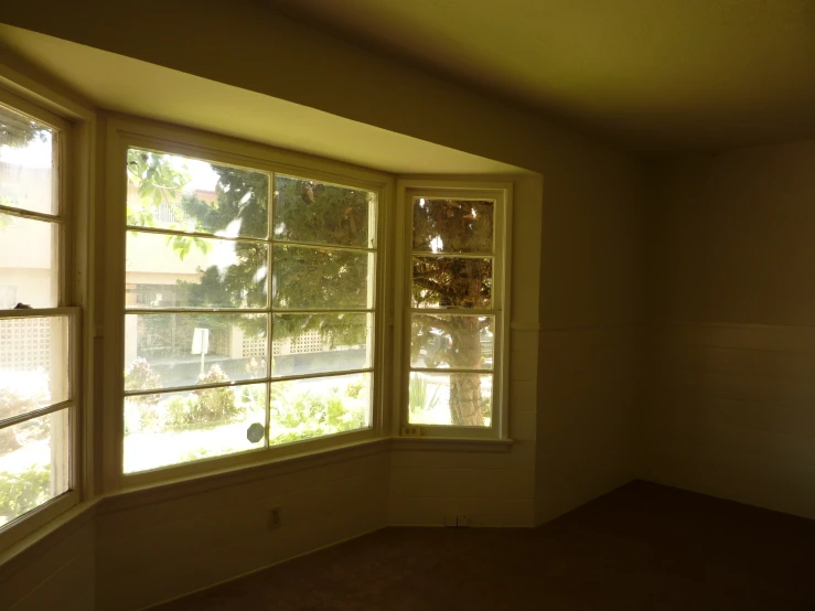 a corner room with an open window in it