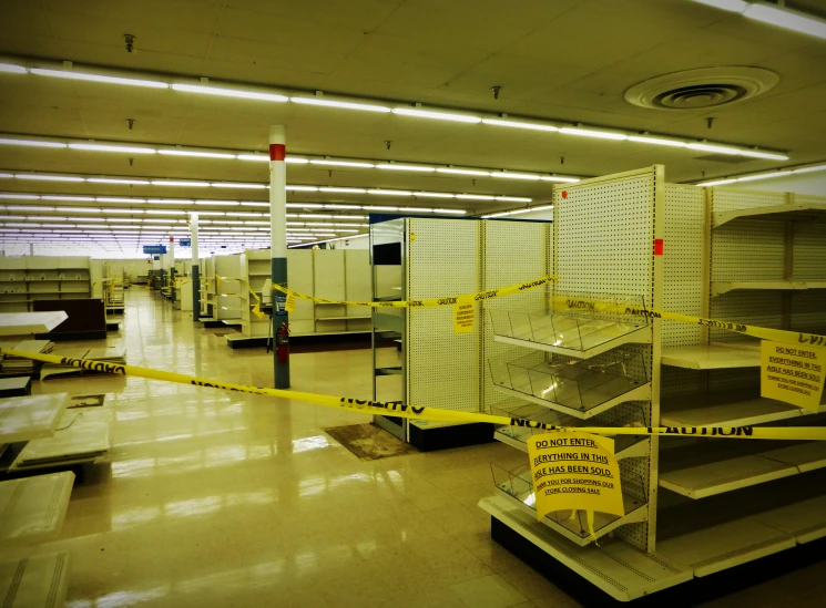 yellow caution tape is around many shelvings in a storage area