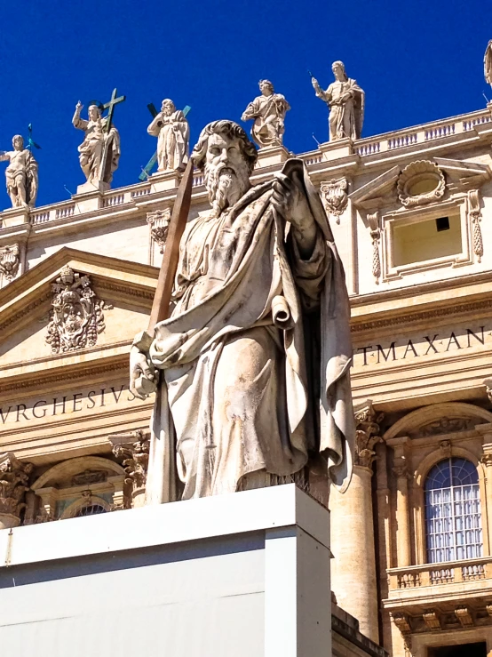 a statue of saint john stands in front of an ornate building