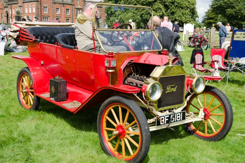 an old model t truck on display with people in the background