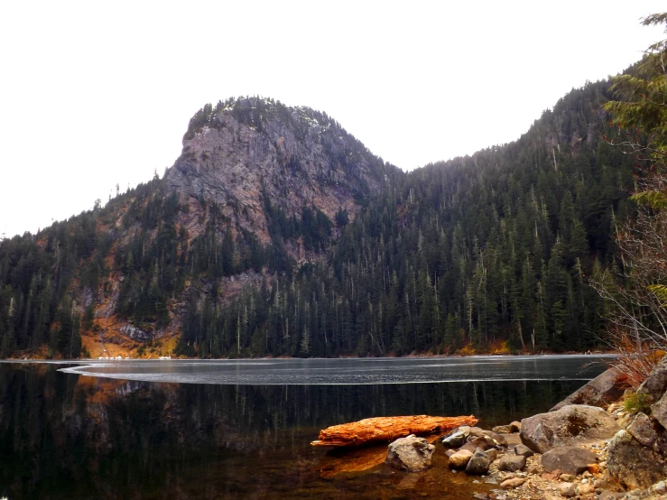 a mountain lake filled with water surrounded by forest