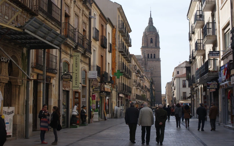 a very tall clock tower sitting above a city street