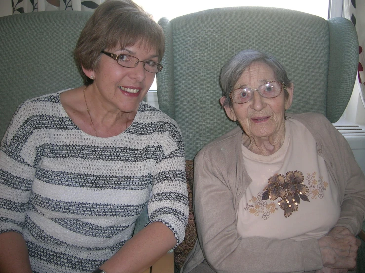 two older ladies siting on some green chairs