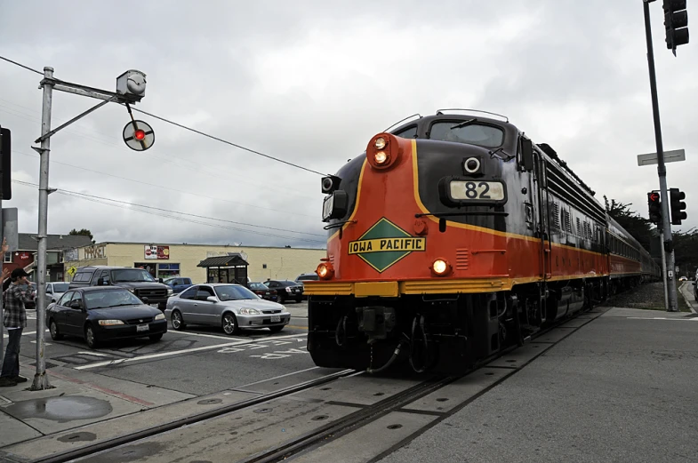 a train traveling past a city on a cloudy day